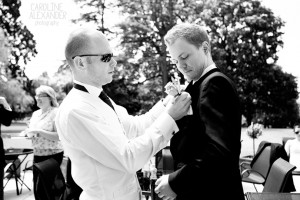 usher helping groom with buttonhole
